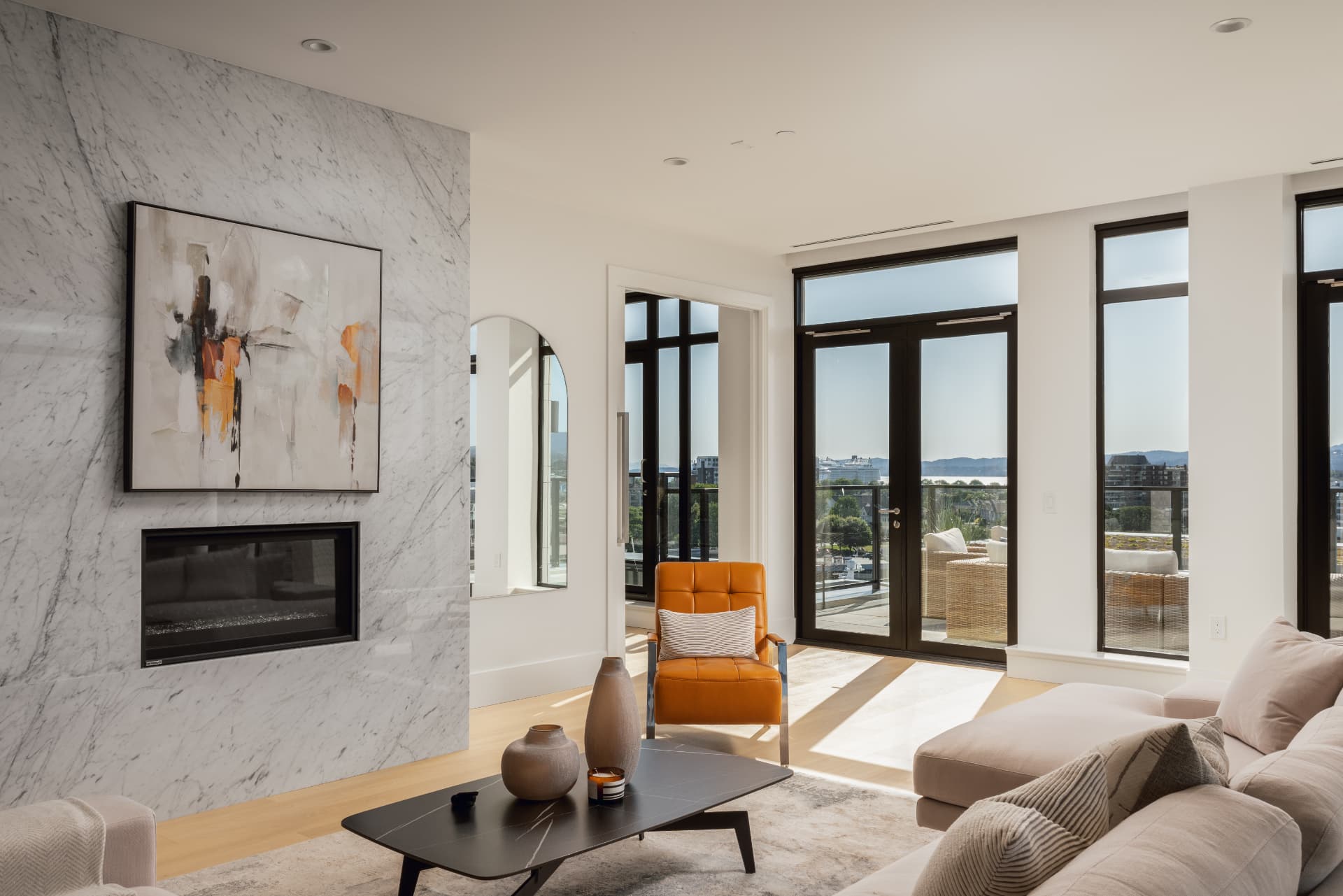 Living room with marble fireplace wall and ocean-view terrace doors