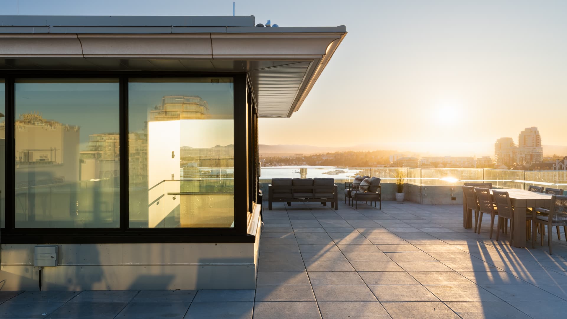 Rooftop penthouse terrace at golden hour above the harbour